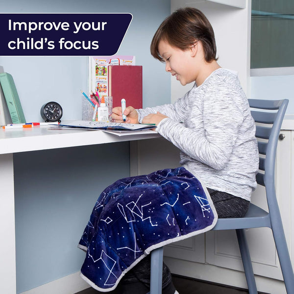 Child working at a desk with a Florensi weighted lap pad across the lap